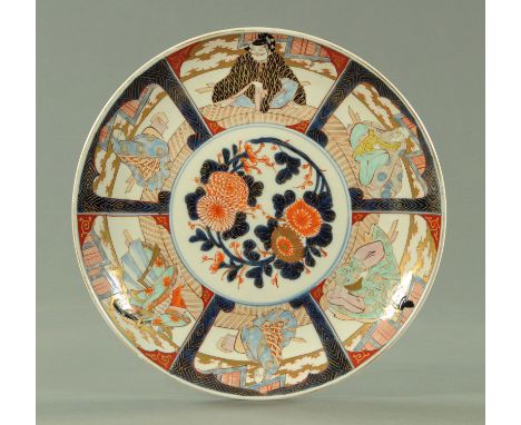 A Japanese Imari charger, circa 1910/20, the central panel of peony and chrysanthemums with blue leaves heightened with gildi