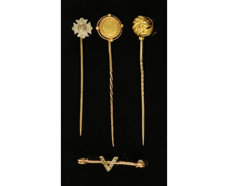 A gold coloured metal pin brooch, in the form of the letter V with seed pearls, and three stick pins. 