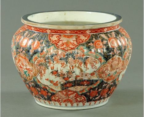 A large Japanese Imari jardiniere, circa 1870/80, panels of chrysanthemums and wisteria within a fenced garden, interspersed 