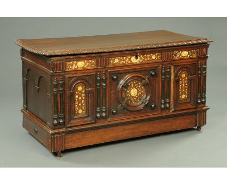 A 19th century oak and bone inlaid coffer, with arched and round mouldings to the panelled front and all raised on castors.  