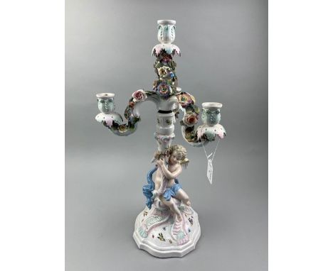 CONTINENTAL CERAMIC CANDELABRUM IN THE STYLE OF MEISSEN, modelled with a cherub and with flowers, 49cm high