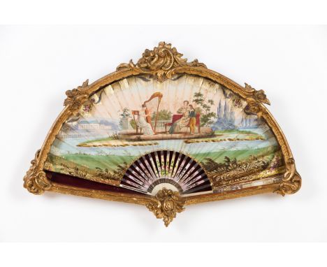 A framed handheld fanPainted parchment with courting scene depicting harp playing lady Ivory sticks and guards of applied gil