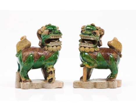 A pair of Buddhist lionsChinese porcelain sculptures depicting Buddhist lions Polychrome decoration in green, yellow and brow