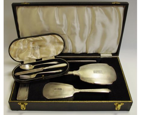 A silver four piece hair brush and hand mirror set, Birmingham 1963, cased; a three piece silver child's christening set, for