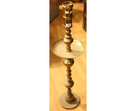 A tall floor standing brass alter type candlestick, dished drip tray, 100cm high