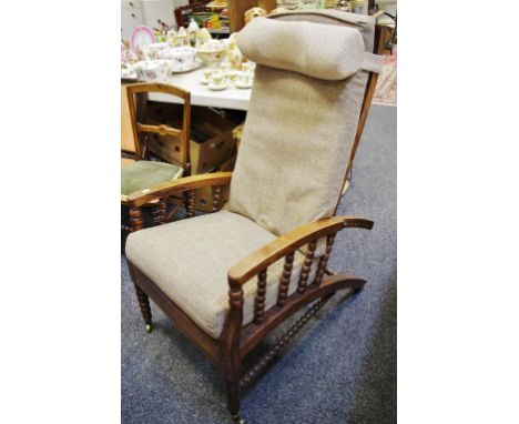 A late Victorian rosewood reclining chair, bobbin turned spindles and stretchers, brass castors to four legs