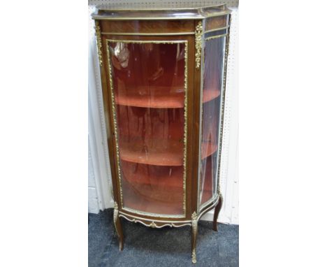 A Louis XVI style gilt metal and mahogany bow fronted display cabinet, the frieze inlaid with vitruvian scrolls, the interior