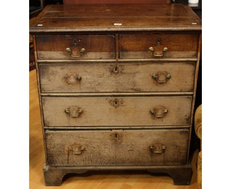 A George III oak chest, slightly oversailing moulded rectangular top above two short and three long graduated drawers, bracke