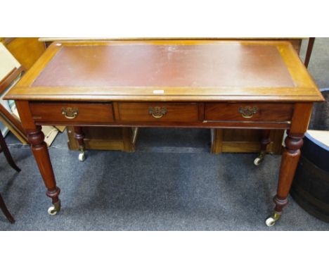 A Victorian mahogany writing desk, leather inlaid top, three drawers to frieze, pierced brass batwing escutcheons, drop swing