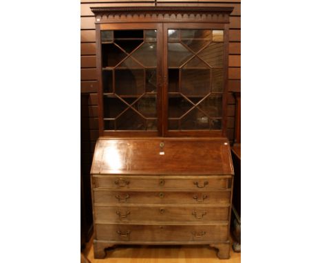 A 'George III' mahogany bureau bookcase, outswept dentil cornice above a pair of astragal glazed doors enclosing three adjust