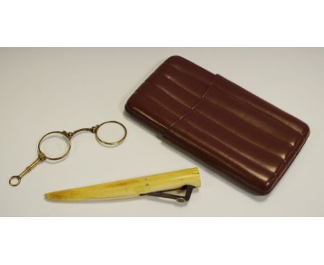 A 19th century marine ivory cigar cutter; a pair of gold plated folding lorgnette, cased; a brown leather cigar case (3)