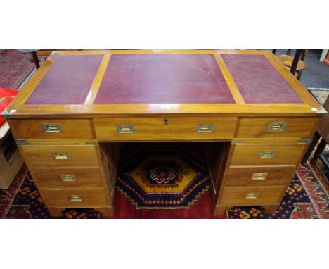 A contemporary campaign style twin pedestal writing desk, rectangular top with inset writing surface above three frieze drawe