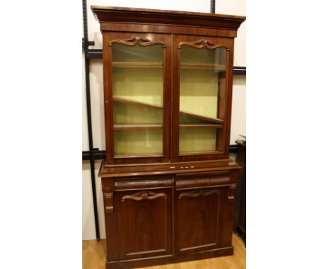 A 'Victorian' mahogany library bookcase, outswept cornice above a pair of glazed doors enclosing three adjustable shelves, th