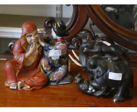 An early ceramic Japanese figure, together with a ebony elephant figure. 