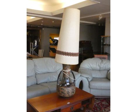 A mid 20th Century ceramic table lamp of bulbous form with raised decoration and large cylindrical fabric shade. 135cm tall. 