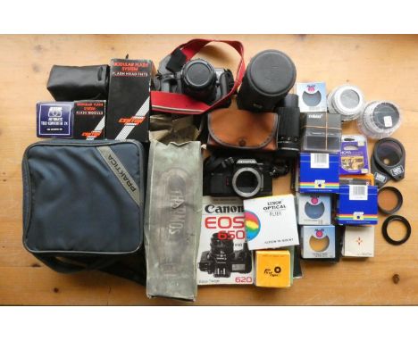 A collection of cameras including a an Olympus OM40, a Canon EOS 650 along with various other assorted camera accessories