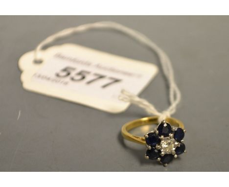 A diamond and sapphire flower head cluster ring, central round brilliant cut diamond, approx 0.16ct, surrounded by six round 