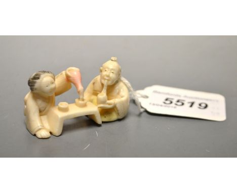 A Japanese carved ivory netsuke of a couple taking sake, signed, Meiji period