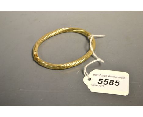 A 9ct gold spiralled hollow hinge bangle, stamped 9ct, 13.4g gross
