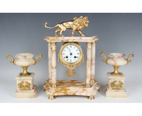 A late 19th/early 20th century gilt metal mounted marble portico clock with eight day movement striking on a bell via an outs