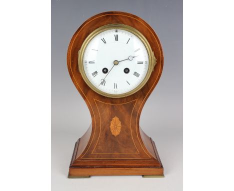 An Edwardian mahogany balloon cased mantel clock with French eight day movement striking hours and half hours on a gong, the 