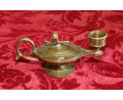 Gilded brass candlestick with scroll handle, the Roman lamp body with dragonfly knop to the lid, 15cm wide.