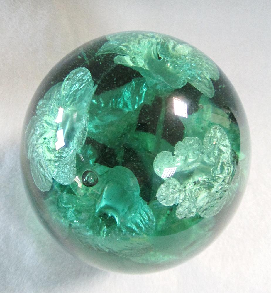 A Victorian green glass dump weight, decorated with flowers issuing