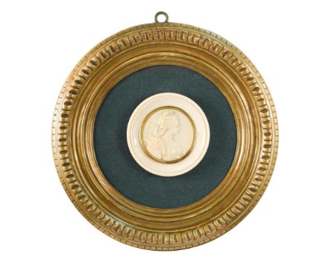 An early 19th century French carved ivory portrait medallion of a lady, possibly Marie Antoinette, with an outer gilt mount a