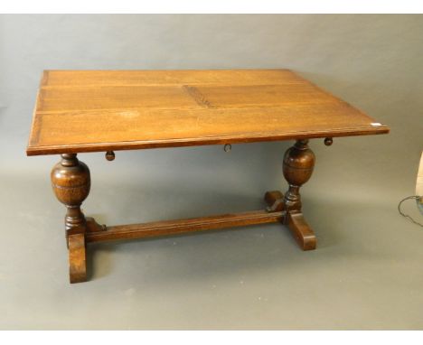 An oak refectory table on bulbous ends and carved and moulded decoration, with pull out 'magic' action leaf, 54'' x 30½'' x 3