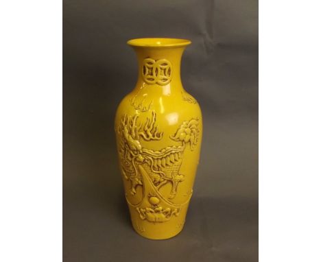 A Chinese yellow ground porcelain vase with relief decoration of a mythical beast and flaming pearl, raised seal mark, 9½'' h