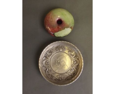 A Chinese multi-coloured hardstone pi-disc, and a Chinese white metal coin dish with relief dragon and flaming pearl decorati