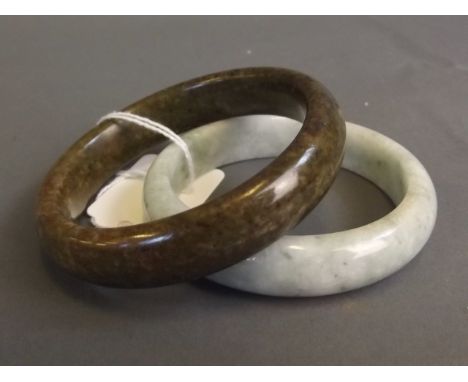 A Chinese mottled green jade bangle, and another hardstone bangle, 3'' diameter