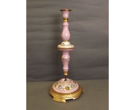 A large C19th Continental porcelain lamp base with a pink ground decorated with gilt scrolls and flowers, on brass mounts, 22