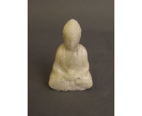 A Chinese mottled white jade pendant carved in the form of Buddha, 2½'' long