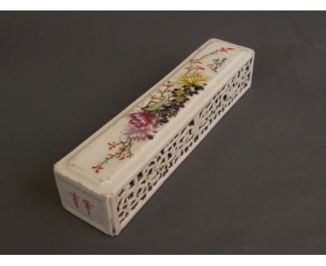 A Chinese porcelain wrist wrest with painted enamel decoration of lotus flowers and a grasshopper, 7½'' long, 1½'' square