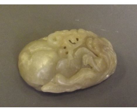 A Chinese celadon jade pendant carved in the form of a kylin sitting on a peach, 2½'' long