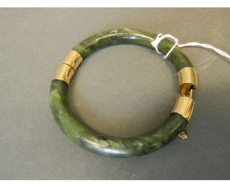 A Chinese jade bangle with gilt metal mounts