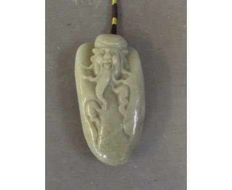 A Chinese carved jade pendant in the form of Lohan, 3½'' long