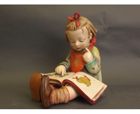 A large Goebel figure of a young girl seated and reading a book, marked and impressed, 10'' high