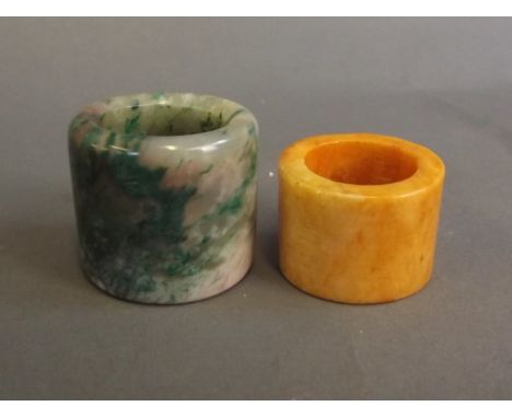 A Chinese mottled green jade archers thumb ring, and another hardstone ring, 1¼'' diameter
