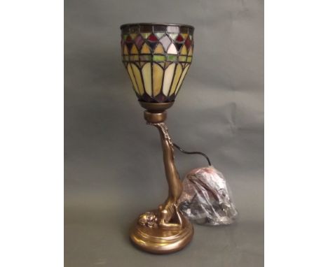 A Tiffany style lamp in the form of a girl balancing the shade on her feet, 18½'' high