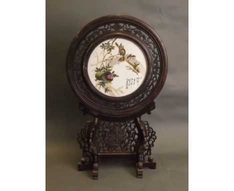 A Chinese circular porcelain panel with painted enamel lovebirds and pomegranate decoration, in a finely carved and pierced h