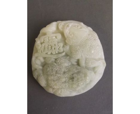 A Chinese mottled jade pendant with carved twin Jin Chan and character decoration, 2'' diameter