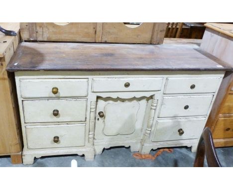 Pine-topped sideboard, the cream painted base with seven drawers and single cupboard door, the whole raised on bracket feet, 