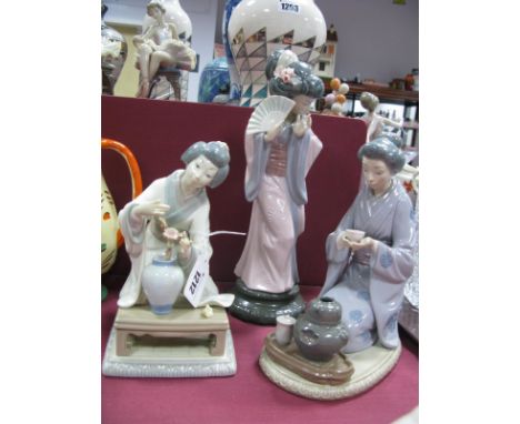 A Lladro Porcelain Model of a Geisha, holding a fan upon a circular modelled base, printed and pressed marks, 30cm high and t