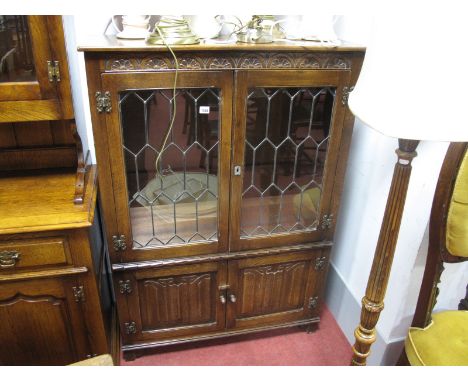 A XX Century Oak Display Cabinet, with leaded glazed doors, linenfold cupboard doors, on bracket feet.