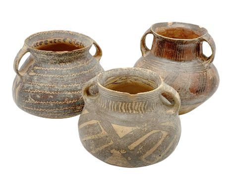 Three Chinese Neolithic pottery vessels, each with twin loop handles to the shoulder and painted geometric banded decoration 