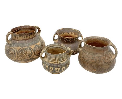 Four Chinese Neolithic pottery vessels, each with twin loop handles to the shoulder and painted geometric banded decoration t