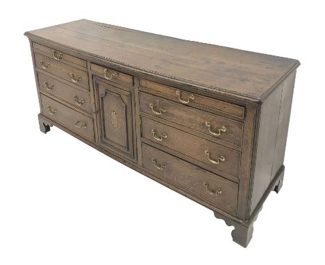 George III Lancashire oak dresser base, moulded top above nine drawers and cupboard door inlaid with fan on bracket feet W186