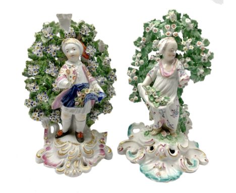 Near pair of bocage figures, the first an 18th century Derby example modelled as a young boy holding flowers, upon a gilt det